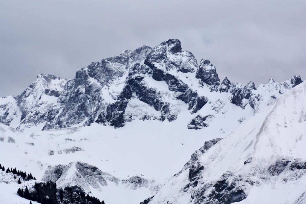 verschneite Berggipfel, aufgenommen durch ein Objektiv mit Autofokusmotor